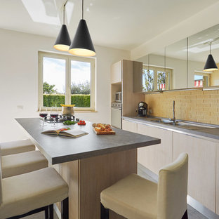 Idee per una cucina contemporanea con ante in legno chiaro, paraspruzzi in mattoni, pavimento in gres porcellanato, pavimento grigio, lavello da incasso, ante lisce, paraspruzzi giallo, elettrodomestici in acciaio inossidabile e top grigio