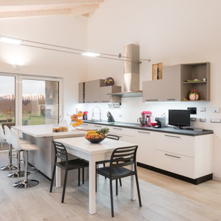 Foto di una cucina contemporanea con lavello sottopiano, ante lisce, ante bianche, parquet chiaro, pavimento beige, top grigio e soffitto a volta