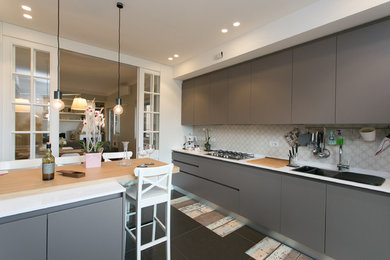 Foto di una cucina abitabile minimal con ante in legno bruno, top in marmo, elettrodomestici in acciaio inossidabile, pavimento in gres porcellanato e penisola