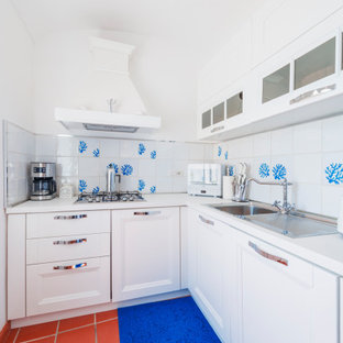 Esempio di una piccola cucina mediterranea con lavello da incasso, ante con riquadro incassato, ante bianche, top in laminato, paraspruzzi bianco, paraspruzzi in gres porcellanato, elettrodomestici bianchi, pavimento in terracotta, pavimento marrone, top bianco e soffitto a volta