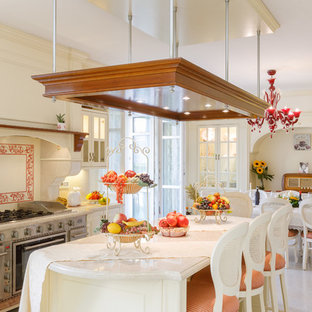 Ispirazione per una cucina classica con ante con bugna sagomata, ante beige, paraspruzzi multicolore, elettrodomestici in acciaio inossidabile, pavimento beige e top beige