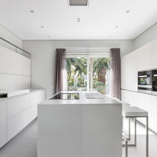 Ispirazione per un grande cucina con isola centrale contemporaneo con ante bianche, paraspruzzi bianco, pavimento bianco, top bianco, ante lisce e elettrodomestici neri