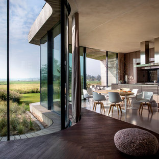Foto de cocina comedor de galera, actual, extra grande, con armarios con paneles lisos, puertas de armario marrones, suelo de cemento y una isla