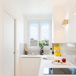 Réalisation d'une petit cuisine design en L fermée avec un évier posé, une crédence multicolore, des portes de placard blanches et aucun îlot.