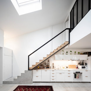 Aménagement d'une grand cuisine linéaire contemporaine avec un évier posé, un placard à porte plane, des portes de placard blanches, un électroménager blanc, aucun îlot, un sol gris et un plan de travail blanc.