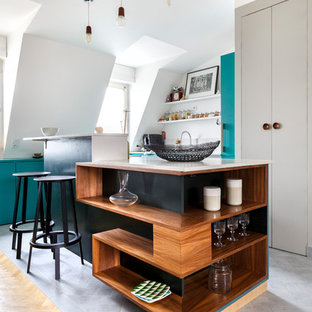 Réalisation d'une cuisine design en L avec un placard sans porte, des portes de placard en bois brun, un îlot central, un sol gris et un plan de travail blanc.