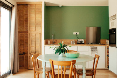 Exemple d'une cuisine ouverte craftsman en L et bois clair de taille moyenne avec un évier encastré, un placard à porte persienne, un plan de travail en bois, une crédence en bois, parquet clair et une crédence marron.