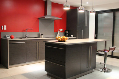 Imagen de cocina comedor contemporánea con armarios con paneles lisos, puertas de armario negras, salpicadero verde, electrodomésticos de acero inoxidable y una isla