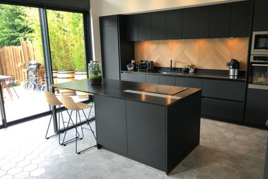 This is an example of a large contemporary open plan kitchen in Lyon with a submerged sink, black cabinets, granite worktops, wood splashback, integrated appliances, cement flooring, an island, grey floors, black worktops and a drop ceiling.
