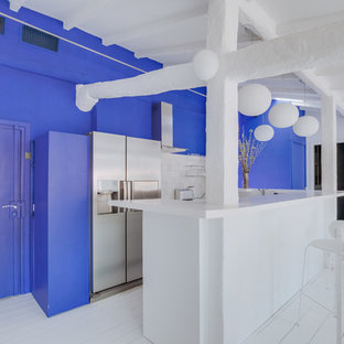 Cette photo montre une cuisine tendance en U avec un placard à porte plane, des portes de placard blanches, une crédence blanche, un électroménager en acier inoxydable, un sol en bois peint, un sol blanc et un plan de travail blanc.