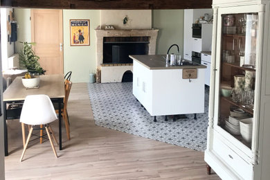 アンジェにある低価格の中くらいなカントリー風のおしゃれなキッチン (アンダーカウンターシンク、白いキャビネット、ラミネートカウンター、シルバーの調理設備、セメントタイルの床、ベージュの床、ベージュのキッチンカウンター) の写真