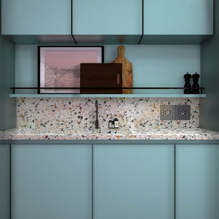 Idee per una cucina moderna di medie dimensioni con lavello integrato, ante a filo, ante blu, top alla veneziana, paraspruzzi multicolore, elettrodomestici da incasso, pavimento in cemento, pavimento grigio e top multicolore
