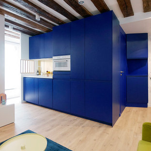 Idee per una cucina moderna di medie dimensioni con lavello a vasca singola, ante a filo, ante blu, top in laminato, paraspruzzi a effetto metallico, elettrodomestici da incasso, parquet chiaro, pavimento beige, top bianco e travi a vista