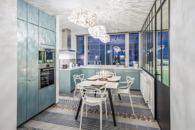 Idée de décoration pour une cuisine design en L fermée avec des portes de placard bleues, une crédence multicolore et un électroménager en acier inoxydable.