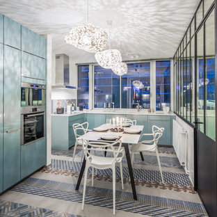 Idée de décoration pour une cuisine design en L fermée avec des portes de placard bleues, une crédence multicolore et un électroménager en acier inoxydable.