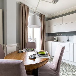 Idées déco pour une cuisine américaine linéaire contemporaine avec des portes de placard blanches, une crédence blanche, un placard à porte plane et aucun îlot.