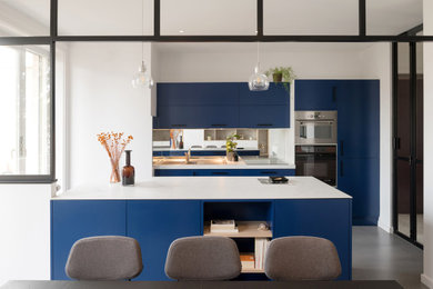 Exemple d'une cuisine ouverte linéaire tendance de taille moyenne avec des portes de placard bleues.
