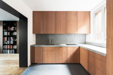 パリにあるコンテンポラリースタイルのおしゃれな独立型キッチン (一体型シンク、インセット扉のキャビネット、赤いキャビネット、テラゾーカウンター、グレーのキッチンパネル、シルバーの調理設備、コンクリートの床、グレーの床、グレーのキッチンカウンター) の写真