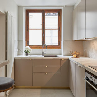 Idées déco pour une cuisine contemporaine en U fermée avec un placard à porte plane, un évier posé, des portes de placard beiges, une crédence blanche, une crédence en dalle de pierre, un électroménager en acier inoxydable, un sol beige et un plan de travail blanc.