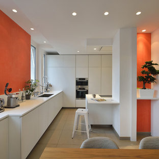 Exemple d'une grand cuisine américaine linéaire tendance avec des portes de placard blanches, une crédence blanche et un îlot central.