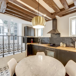 Réalisation d'une cuisine américaine tradition en L avec un évier 1 bac, un placard à porte shaker, des portes de placard grises, un plan de travail en bois, une crédence grise, aucun îlot et un sol multicolore.