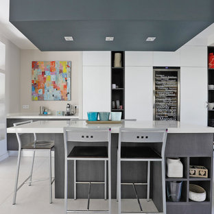 Idées déco pour une cuisine américaine contemporaine avec un placard à porte plane, des portes de placard grises, 2 îlots et un sol blanc.