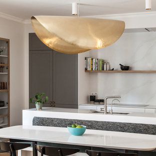 Inspiration pour une cuisine nordique avec un sol en bois clair, un évier encastré, un placard à porte shaker, des portes de placard grises, une crédence blanche, une crédence en dalle de pierre, un îlot central et un plan de travail blanc.