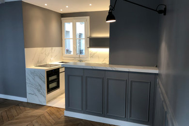 パリにある高級な中くらいなコンテンポラリースタイルのおしゃれなキッチン (シングルシンク、白いキャビネット、大理石カウンター、大理石のキッチンパネル、黒い調理設備、大理石の床、アイランドなし、白いキッチンカウンター) の写真
