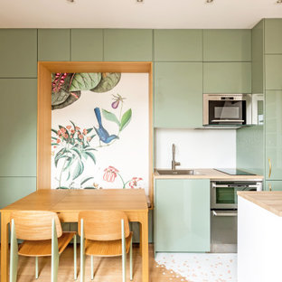 Idée de décoration pour une cuisine ouverte linéaire style shabby chic de taille moyenne avec un évier encastré, un placard à porte affleurante, des portes de placards vertess, un plan de travail en stratifié, une crédence blanche, une crédence en mosaïque, un électroménager en acier inoxydable, un sol en bois clair, un îlot central, un sol marron et un plan de travail marron.