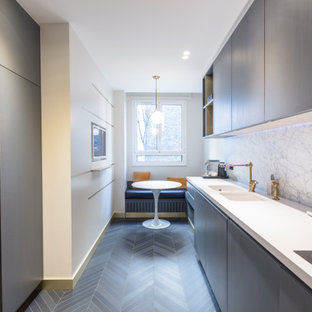 Inspiration pour une cuisine design avec un évier 2 bacs, un placard à porte plane, des portes de placard marrons, une crédence blanche, une crédence en dalle de pierre, aucun îlot, un sol gris et un plan de travail blanc.
