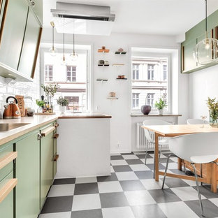 Idéer för ett 50 tals beige linjärt kök och matrum, med en nedsänkt diskho, släta luckor, gröna skåp, träbänkskiva, vitt stänkskydd, stänkskydd i tunnelbanekakel, integrerade vitvaror och flerfärgat golv