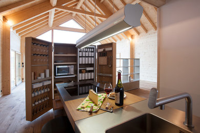 Aménagement d'une petite cuisine ouverte linéaire scandinave en bois brun avec un évier intégré, un électroménager en acier inoxydable et un sol en bois brun.