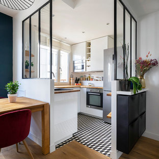 Inspiration for a small contemporary u-shaped separate kitchen in Paris with a single-bowl sink, white cabinets, wood benchtops, white splashback, stainless steel appliances, ceramic floors, no island, brown benchtop, flat-panel cabinets and multi-coloured floor.