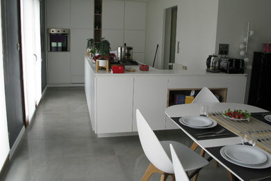 Imagen de cocina comedor minimalista de tamaño medio con electrodomésticos de acero inoxidable, suelo de baldosas de cerámica y una isla