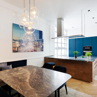 Idées déco pour une cuisine américaine contemporaine avec un placard à porte plane, des portes de placard bleues, un îlot central et un sol multicolore.