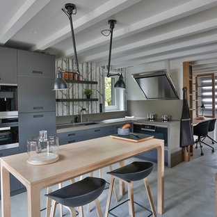 Inspiration pour une grand cuisine américaine design en L avec un évier 1 bac, des portes de placard grises et aucun îlot.