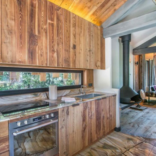 Aménagement d'une cuisine ouverte linéaire montagne de taille moyenne avec un évier encastré, un plan de travail en bois, un électroménager encastrable, un sol en bois brun et aucun îlot.