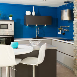 Diseño de cocina comedor en L, contemporánea, pequeña, con fregadero integrado, puertas de armario blancas, encimera de acero inoxidable, salpicadero azul y una isla