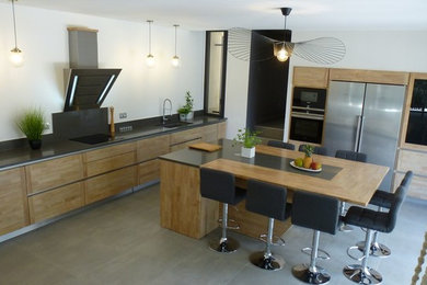 Design ideas for a large contemporary l-shaped open plan kitchen in Marseille with an integrated sink, flat-panel cabinets, light wood cabinets, quartz worktops, yellow splashback, stainless steel appliances, ceramic flooring, an island, grey floors and grey worktops.