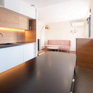 Idées déco pour une cuisine ouverte linéaire contemporaine de taille moyenne avec un placard à porte plane, des portes de placard blanches, une crédence en bois, aucun îlot, un évier intégré, un plan de travail en stratifié, un électroménager encastrable, un sol en linoléum, un sol multicolore et un plan de travail gris.