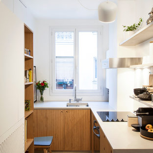 Idée de décoration pour une petit cuisine design en L fermée avec un placard à porte plane, des portes de placard en bois brun, un électroménager noir, aucun îlot, un évier encastré et une crédence blanche.
