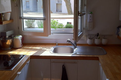 Cette photo montre une cuisine en U avec un évier encastré et un plan de travail en bois.