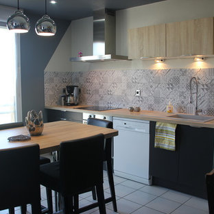 Inspiration for a mid-sized contemporary galley eat-in kitchen in Toulouse with an integrated sink, beaded inset cabinets, black cabinets, laminate benchtops, grey splashback, cement tile splashback, stainless steel appliances, ceramic floors, with island and grey floor.