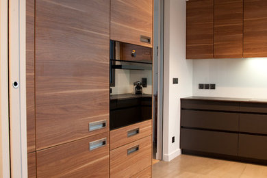 Idées déco pour une cuisine contemporaine en bois brun avec un évier 1 bac, un placard à porte affleurante, une crédence blanche, une crédence en feuille de verre et un électroménager noir.