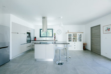 Exemple d'une cuisine linéaire tendance de taille moyenne avec un évier encastré, un placard à porte affleurante, des portes de placard blanches, un électroménager blanc, aucun îlot, un sol gris et un plan de travail gris.