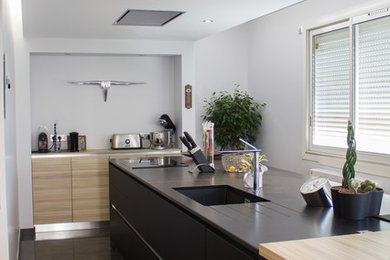Geschlossene, Zweizeilige, Große Moderne Küche mit integriertem Waschbecken, schwarzen Schränken, Granit-Arbeitsplatte, bunten Elektrogeräten und Kücheninsel in Grenoble
