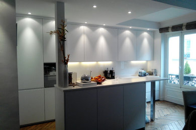 Cette image montre une cuisine ouverte parallèle minimaliste de taille moyenne avec une crédence blanche et îlot.