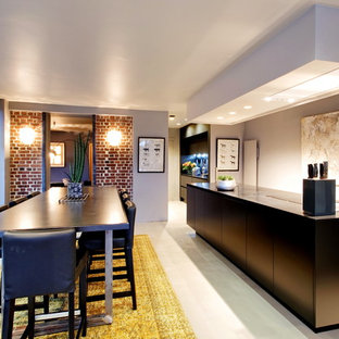 Aménagement d'une grand cuisine américaine contemporaine avec des portes de placard noires et un îlot central.