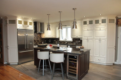 Example of a mid-sized classic l-shaped ceramic tile open concept kitchen design in Montreal with an undermount sink, raised-panel cabinets, white cabinets, granite countertops, brown backsplash, mosaic tile backsplash, stainless steel appliances and an island