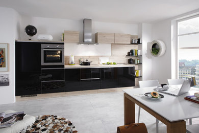 Medium sized contemporary single-wall open plan kitchen in Lyon with stainless steel appliances and no island.
